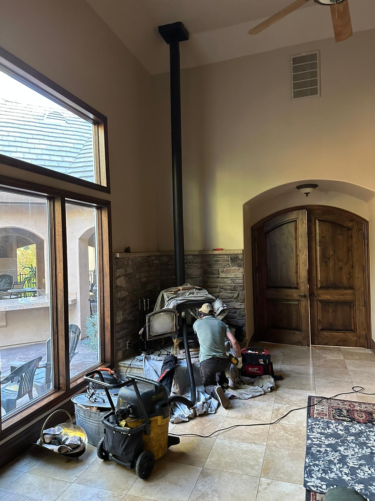 CSIA certified chimney sweep technician cleaning a fireplace flue in Sherman Oaks CA